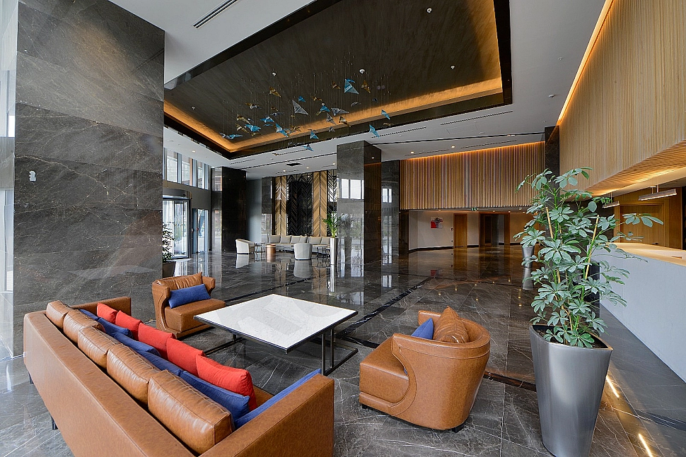 Modern building entrance facade, glass and metal details, landscaping