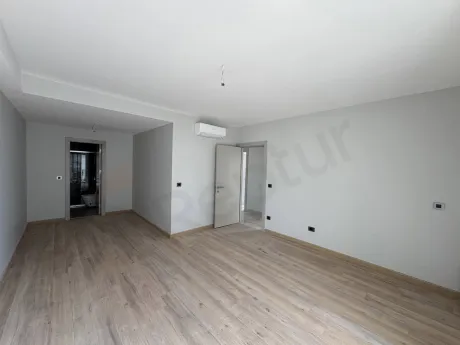 Interior view of a spacious and bright bedroom in a modern apartment.