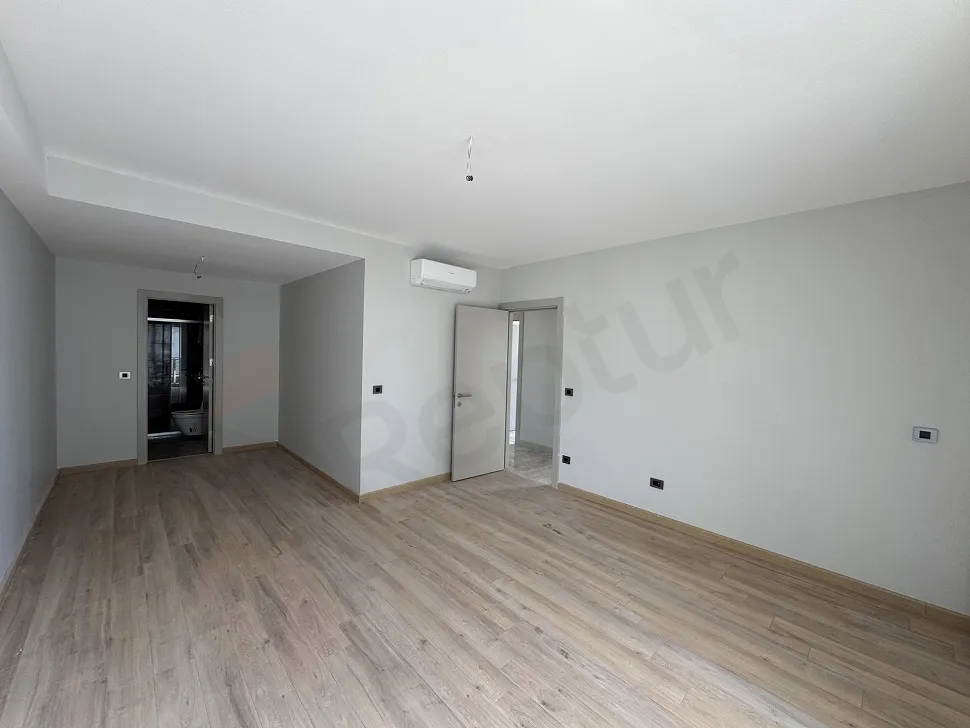 Interior view of a spacious and bright bedroom in a modern apartment.