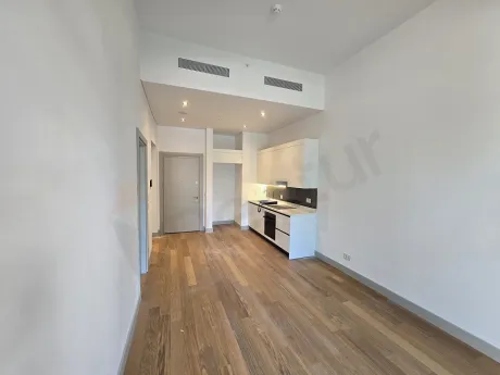 Living room of a bright 1+1 apartment with modern architecture, large windows, and a city view in Sisli.