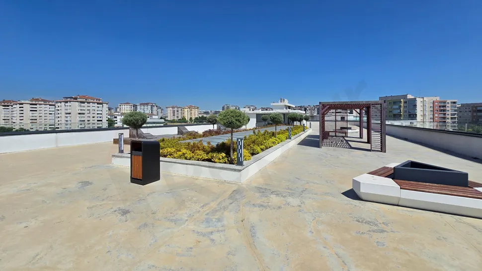 View of a spacious and airy roof terrace of a modern building.