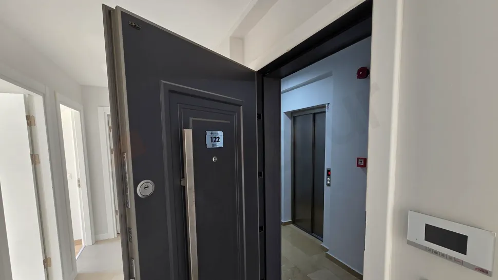 The entrance door and hallway area of an apartment in a modern building.