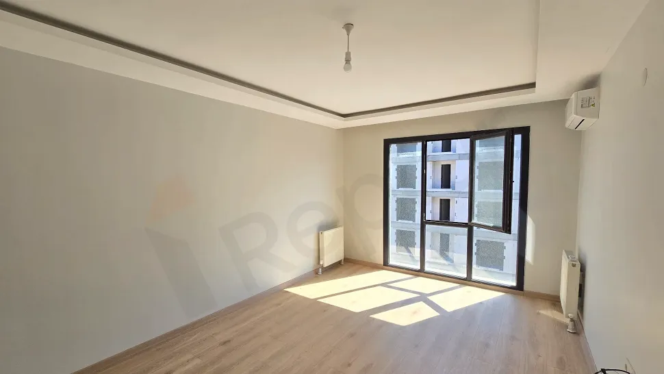 Spacious and bright empty living room area with large windows in a modern building in Küçükçekmece.