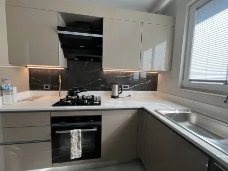 The kitchen area inside a modern and spacious apartment.