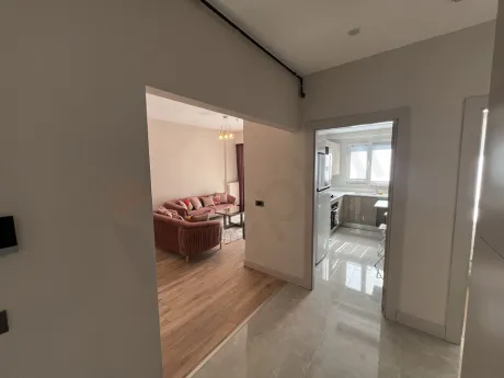 Empty modern corridor of an apartment with light-colored walls and flooring.