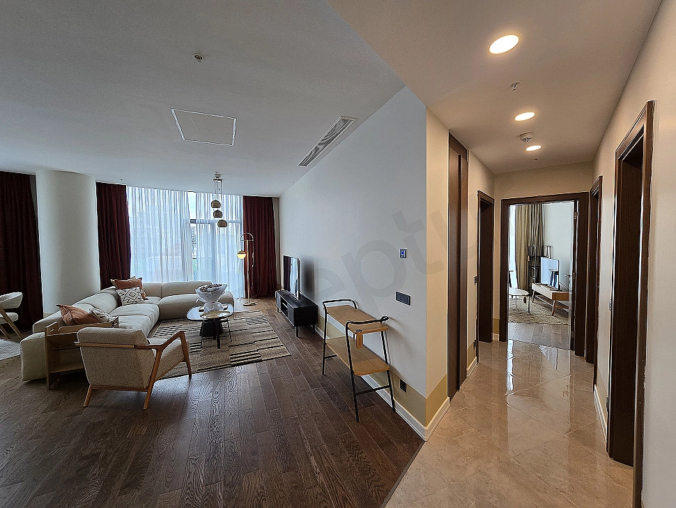 Stylish and modern living room design with comfortable sectional sofa, wood details and natural light.