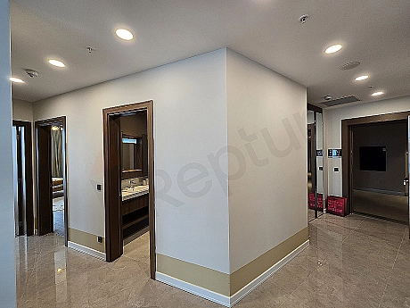 Modern designed, bright and spacious hallway. Wooden floor, white walls, and stylish lighting details.