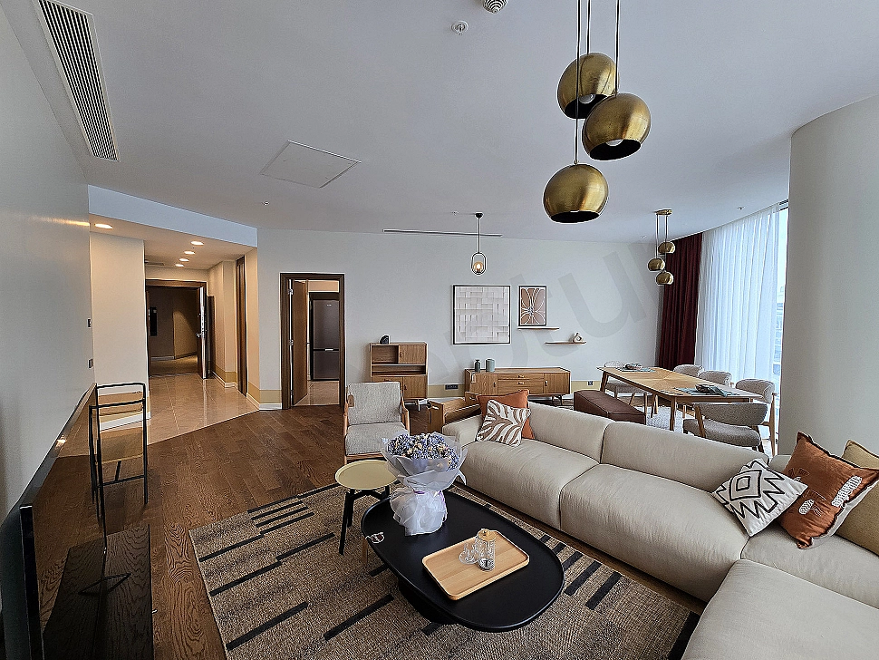 Modern living room design: spacious corner sofa, stylish coffee table, bright window, and decorative objects.