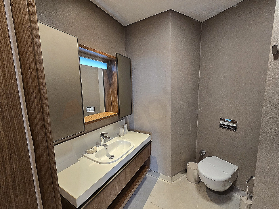 Luxurious bathroom with modern design, white ceramic sink and large mirror.