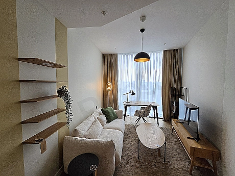Modern home office design: wooden desk, bookcase, comfortable chair, and city view.