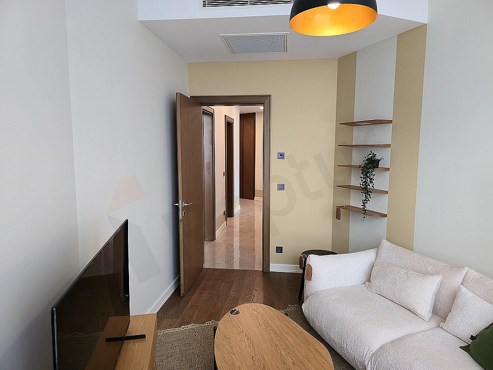 Modern study room: wooden desk, ergonomic chair, bookshelf and city view window.