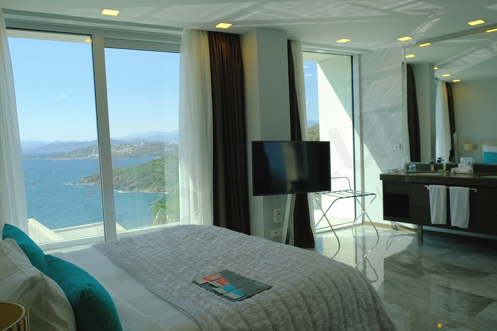 A modernly designed bedroom featuring a double bed, nightstands, and a wardrobe.