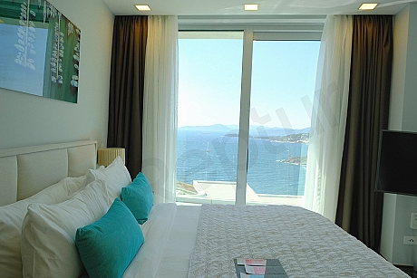 A modern and comfortable bedroom featuring a double bed, two bedside tables, lighting fixtures, and minimalist decor.