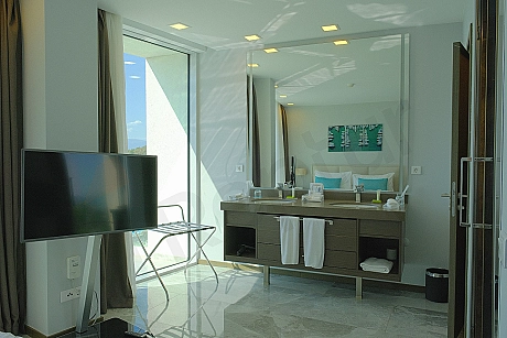 Interior view of a modern and furnished bedroom with a comfortable bed, stylish furniture, and bright ambiance.