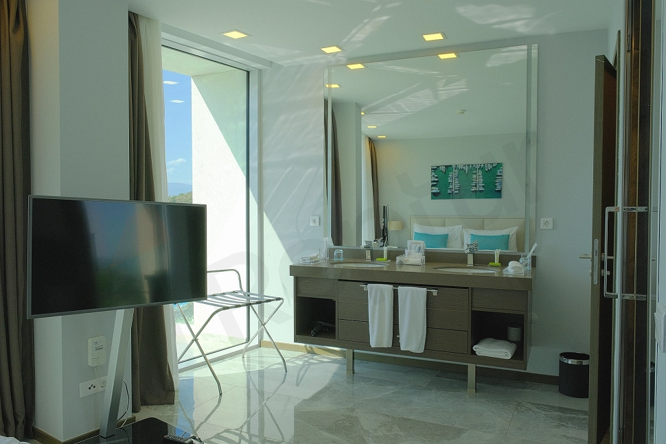 Interior view of a modern and furnished bedroom with a comfortable bed, stylish furniture, and bright ambiance.