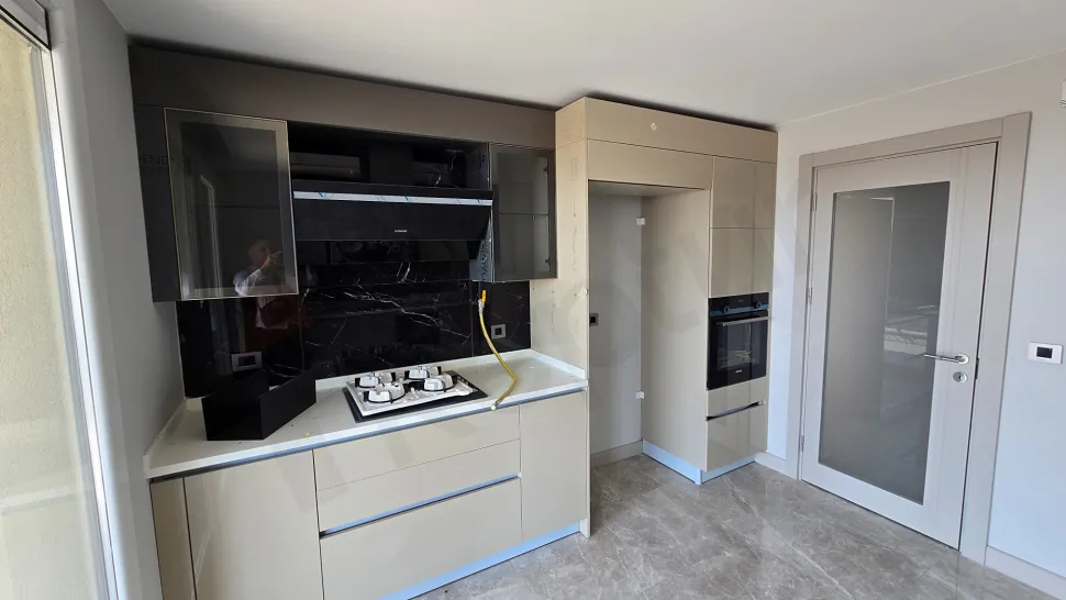 General view of a modern and spacious apartment kitchen.