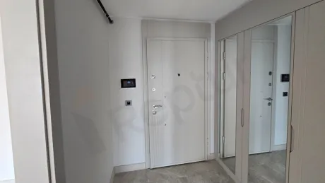 Spacious and bright apartment entrance and hallway area in a modern building.