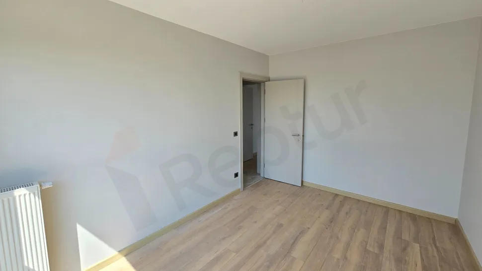A bright bedroom image with large windows and modern design located in a new building.