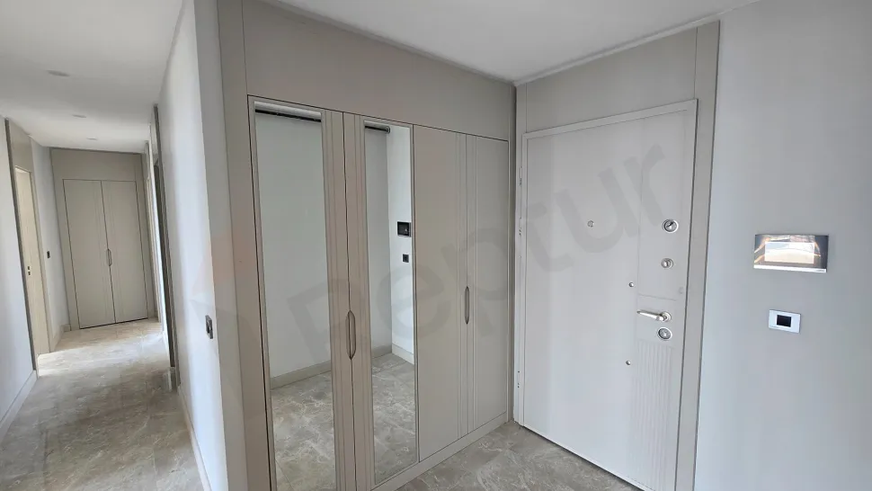 The entrance door and spacious hallway area of a modern apartment.