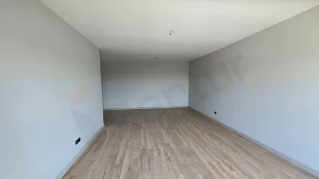A spacious, bright, and empty living room area with a city view in a modern building in Beylikdüzü.