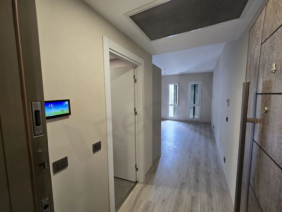 Entrance door and hallway of a modern apartment unit.