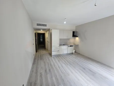 Spacious and bright living room area of a modern studio apartment.