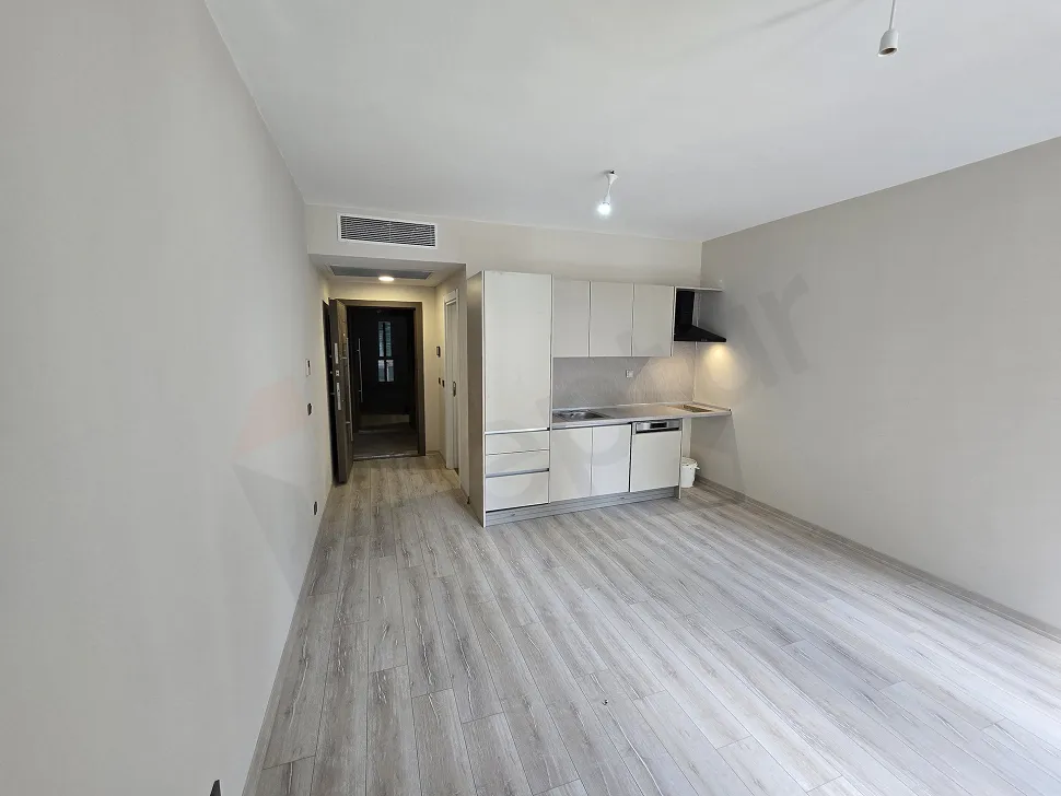 Spacious and bright living room area of a modern studio apartment.