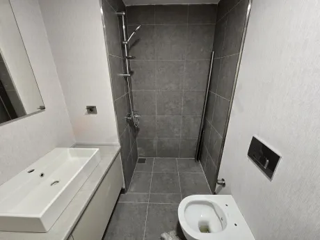 Modern bathroom design with light-colored ceramic tiles and mirror.