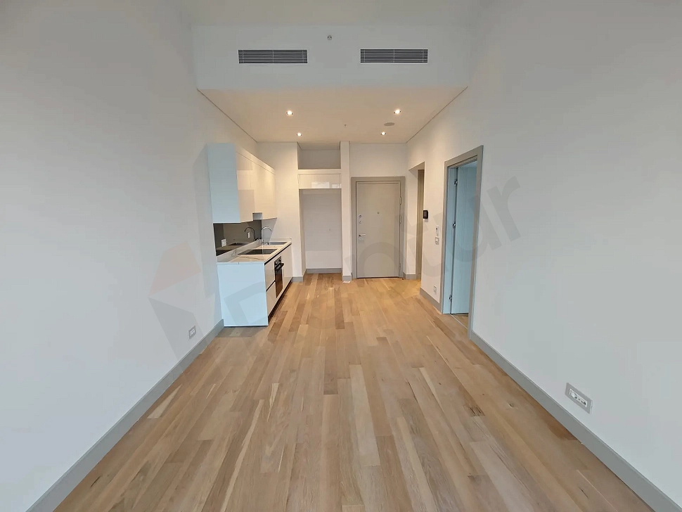 Modern living room area of a luxury residence with large windows and natural light.