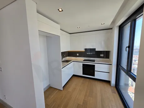 Modern open-plan kitchen area with spacious design, cabinetry, and countertop details.