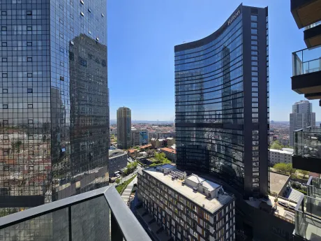 Spacious and open balcony area of a modern residence apartment with a city view.