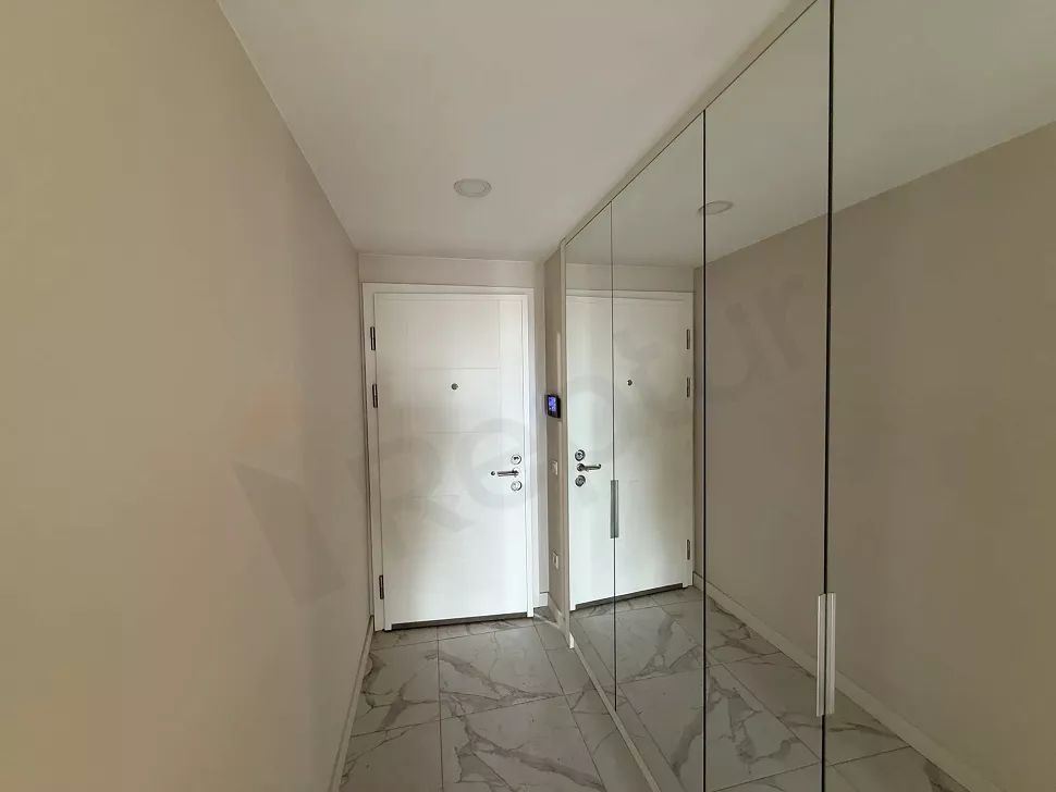 Spacious entrance hall and front door view of a modern apartment.