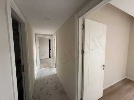 A wide and bright hallway view located in the interior of a new and modern building.