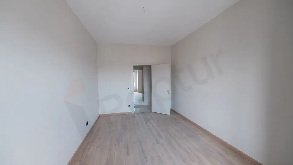 Spacious bedroom with a modern and bright design featuring large windows.