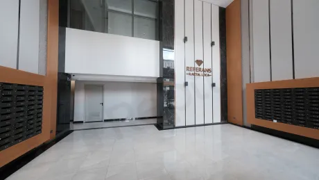 Stylish and spacious lobby area of a modern building with a reception desk and modern interior design details.