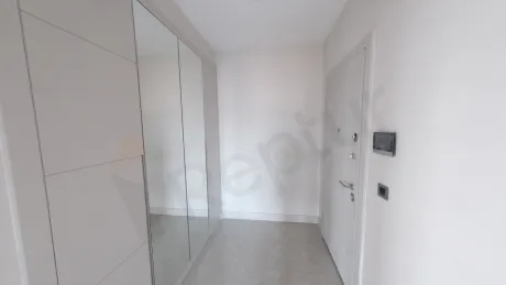 View of a spacious entrance hallway and front door of a modern apartment.