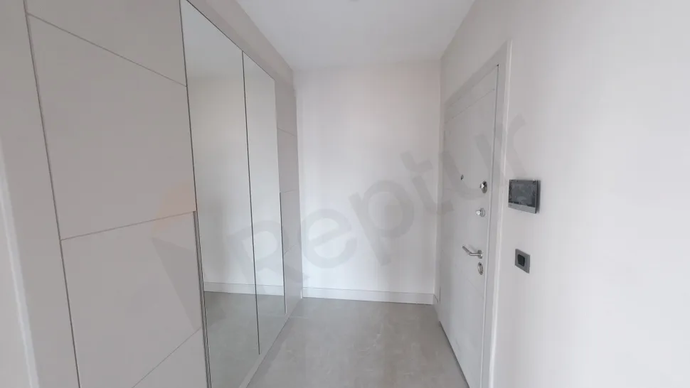 View of a spacious entrance hallway and front door of a modern apartment.