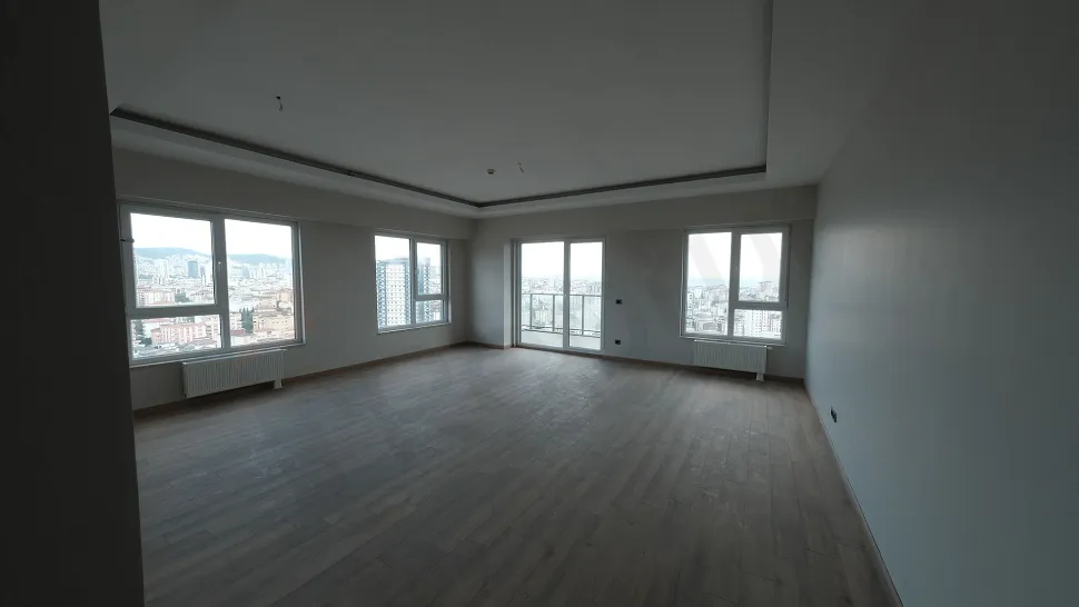 Interior view of a spacious, bright, and modern living room with large windows.