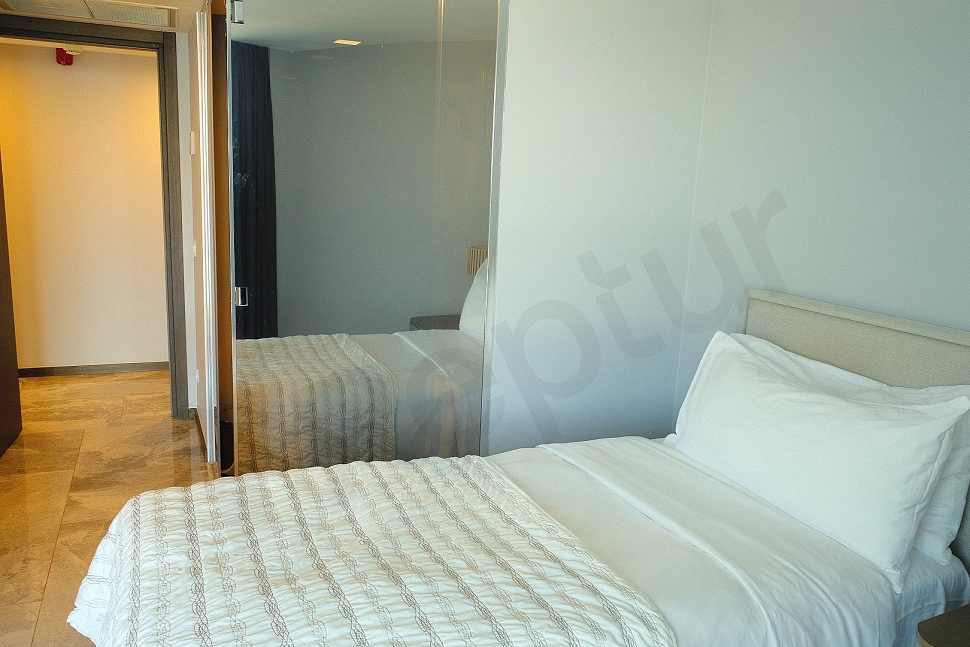 A view of a modernly decorated, spacious, and comfortably furnished bedroom.