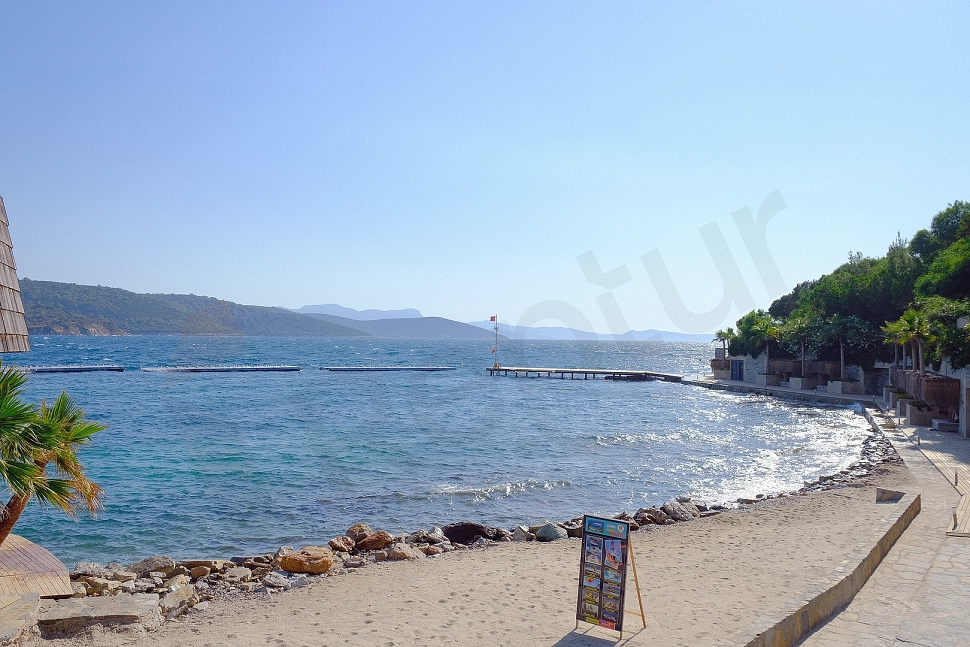 Private beach area in Bodrum featuring clear sea and sandy shoreline.