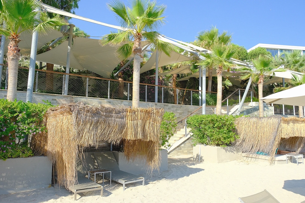 A view of a luxury private beach area with turquoise sea and fine sand.