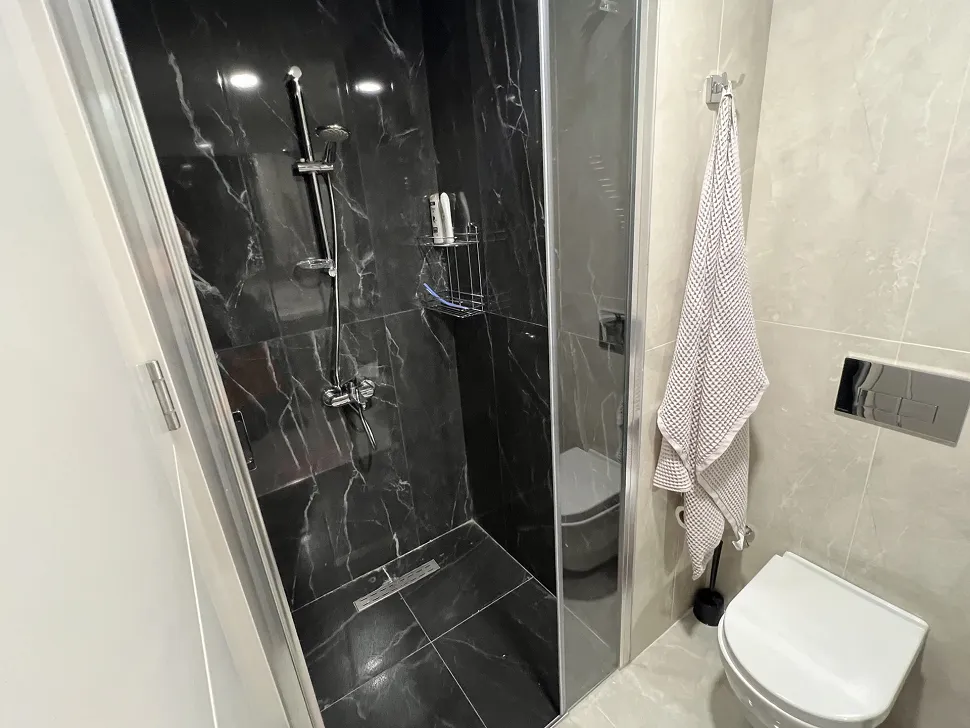 Stylish bathroom with modern design, high-quality ceramic tiles, and a spacious shower area.