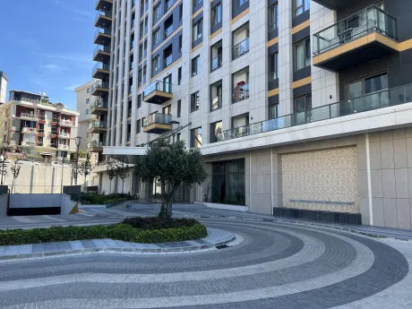 A spacious and green landscaped garden area within a modern residential complex.