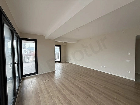 A spacious and bright empty living room area with large windows and modern architectural design.
