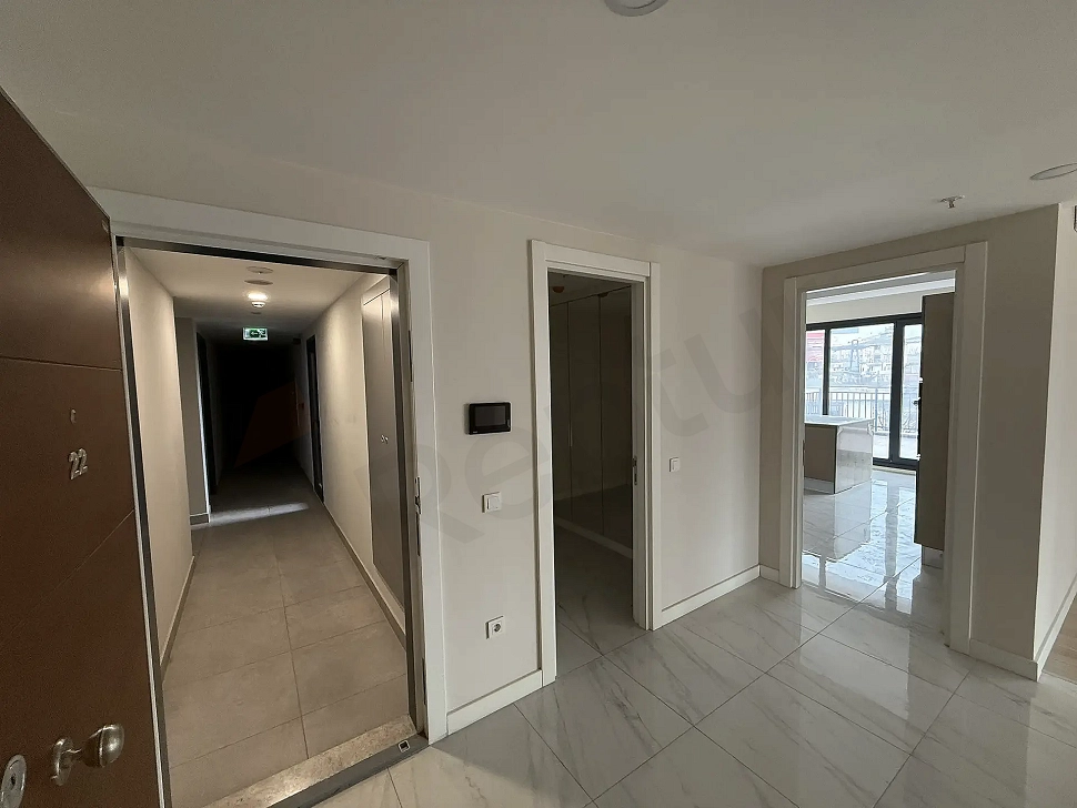 Spacious and bright apartment entrance and hallway area in a modern building.