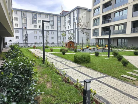 Landscaped green garden area and walking paths of a modern residential complex.