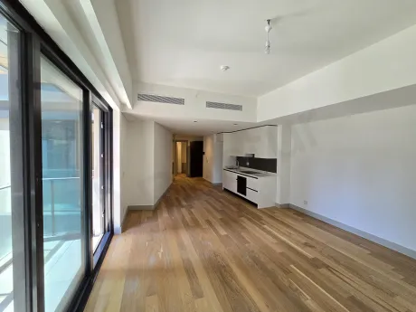 View of a bright, modern living room with large windows.