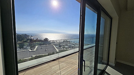 A spacious and modern apartment terrace opening to a sea view.