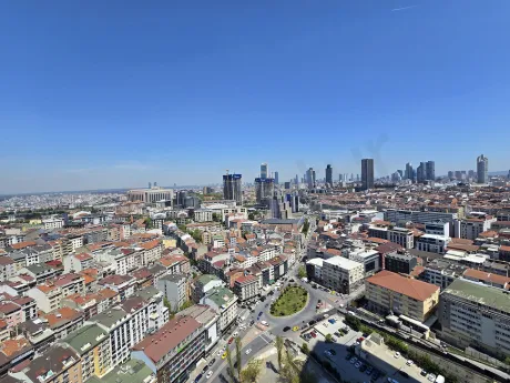 A modern and spacious apartment balcony opening to a city view.