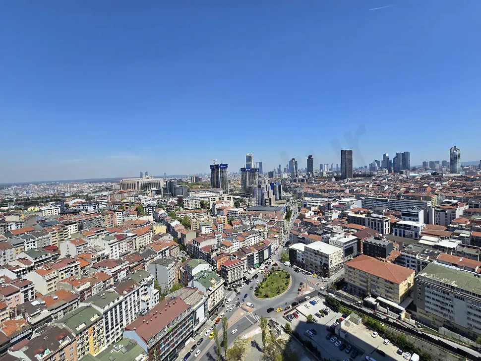 A modern and spacious apartment balcony opening to a city view.